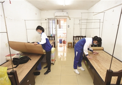 在湛江市第二中学学生宿舍里,返校学生正在整理内务.
