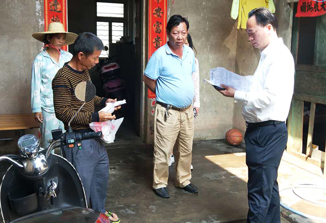 湖光岩风景区管理局党组书记、局长陆明贤（右一）走访里光村贫困户.jpg